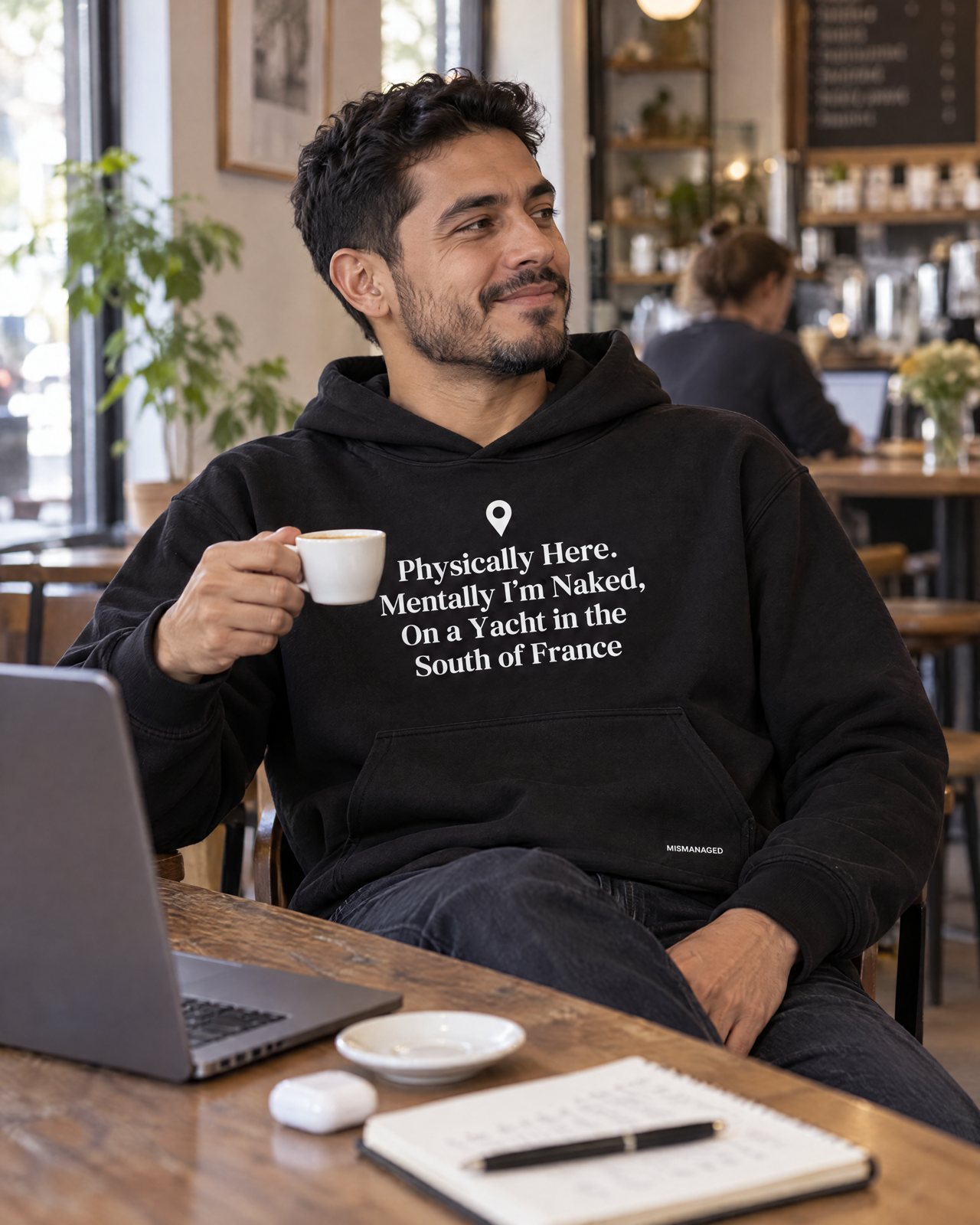 Model wearing the South of France hoodie, front view, in a cafe, lifestyle view